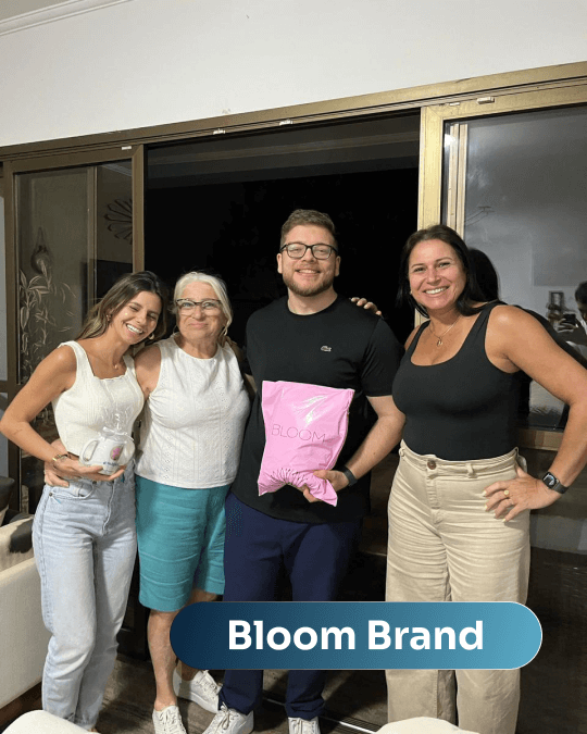 Vítor Parraga com o time da Bloom Brand, segurando a embalagem rosa da marca